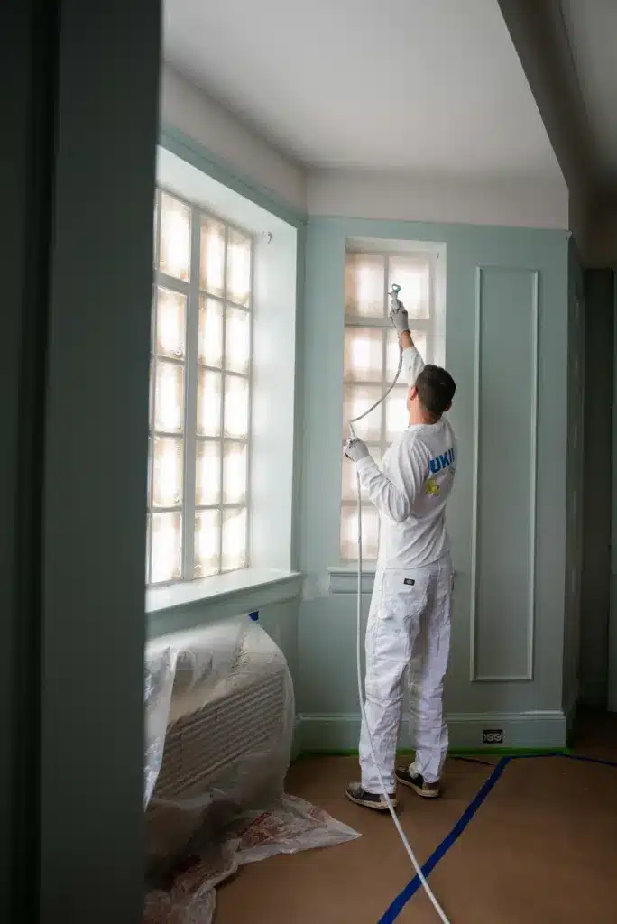 Painter applying a sprayed coating with professional equipment